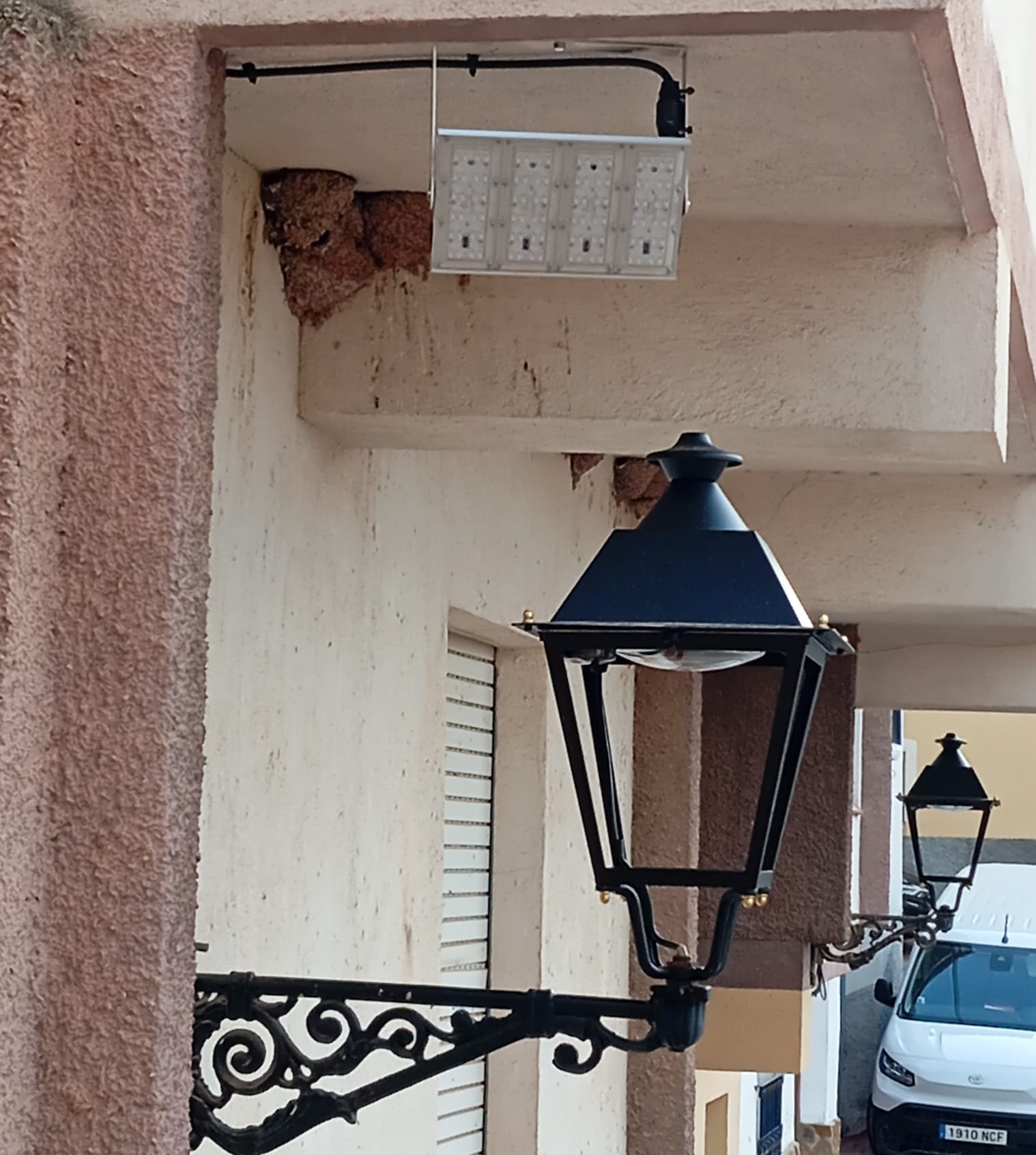 Punto de luz LED instalado junto a una farola tradicional en una calle de Zarra.